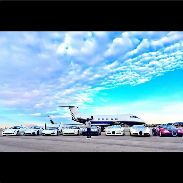 Floyd Mayweather and eight luxury cars in front of a private jet